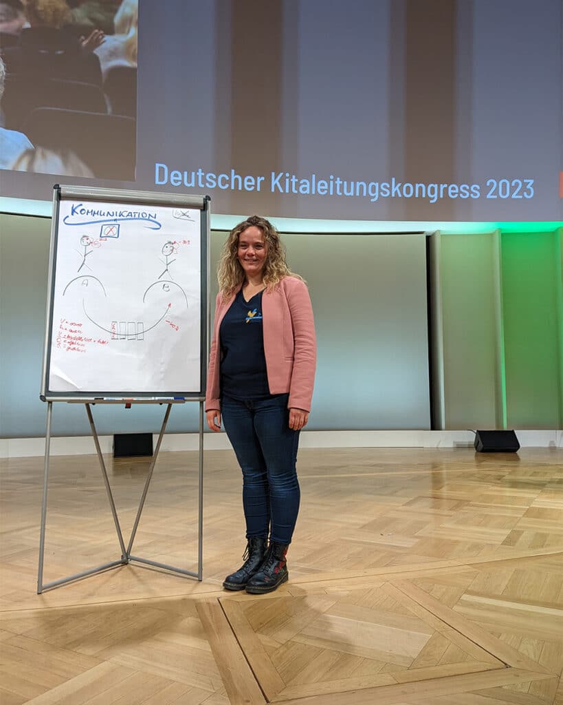 Claudia bei einem Vortrag der DKLK vor einem Flipchart