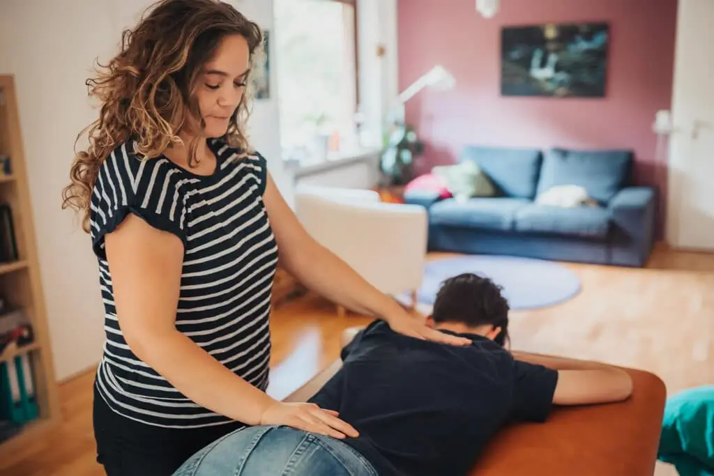 Reflexintegrationstrainerin Claudia Hannemann bei einer passiven Übung mit einem Kind auf der Liege – sanfte Bewegungsimpulse zur Integration frühkindlicher Reflexe bei ADHS-Symptomen.